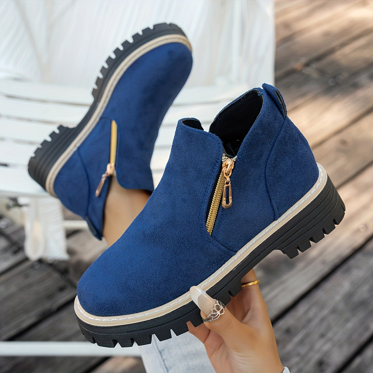 Blue ELARA ankle boots held to show chunky soles