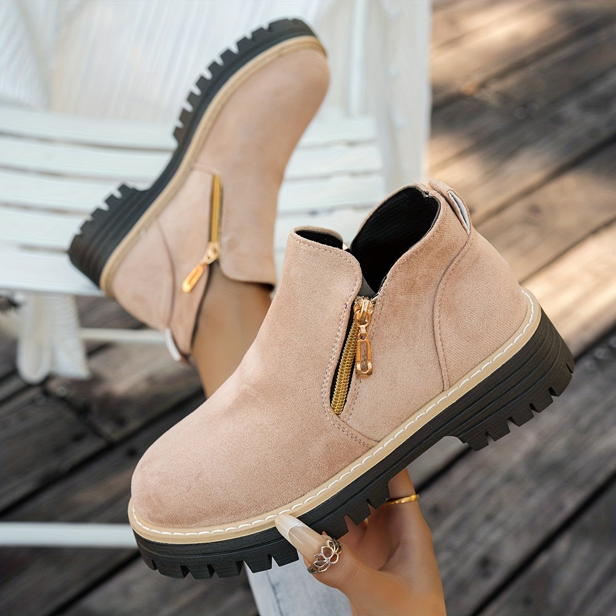 Beige ELARA ankle boots held to show side zips