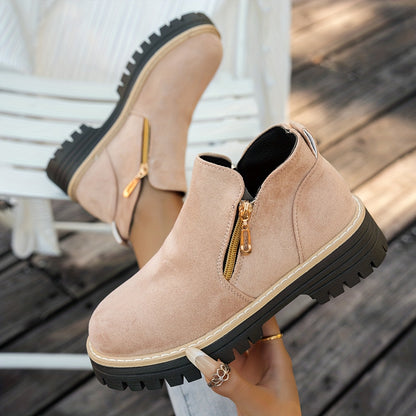Beige ELARA ankle boots held to show side zips