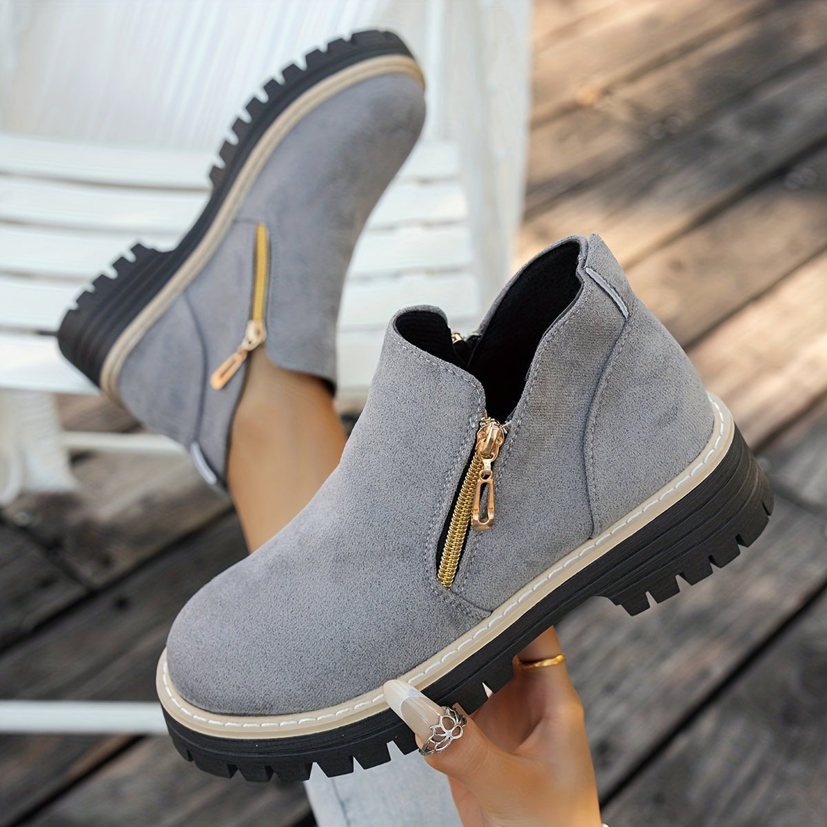 Grey ELARA ankle boots held to show side zips