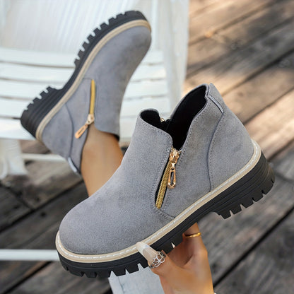 Grey ELARA ankle boots held to show side zips